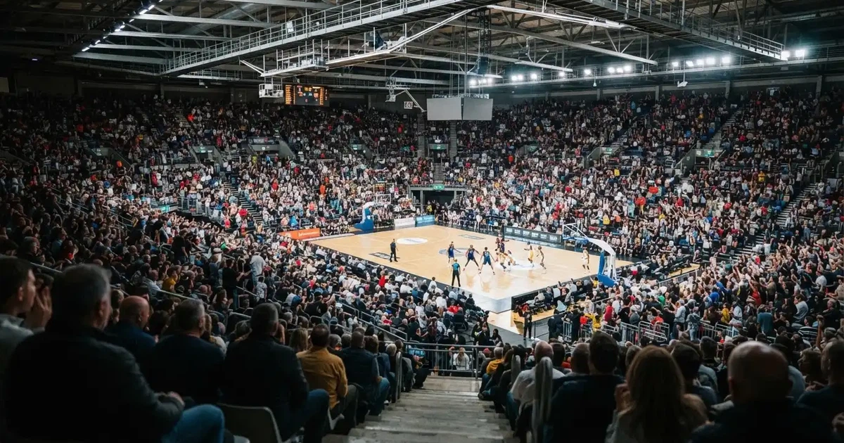 Een volle sporthal onder schijnwerpers, van grote afstand gefotografeerd